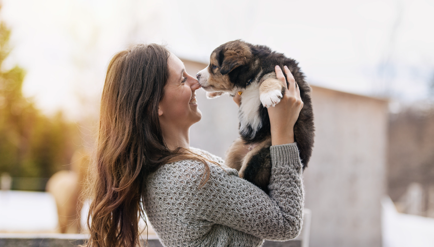 puppy kissing a woman's nose