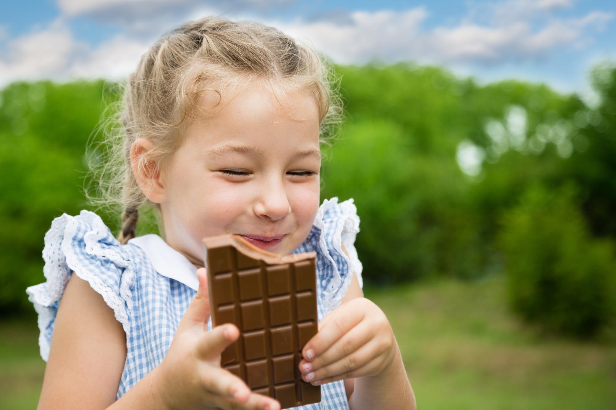 girl eating a chocolate bar with joy