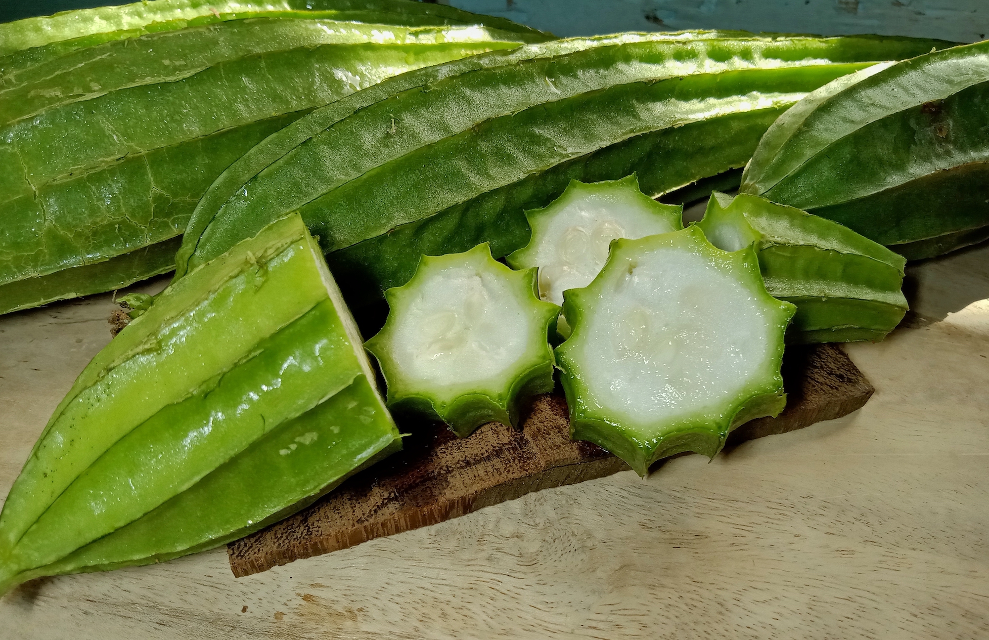 Luffa acutangula sliced on a cutting board.