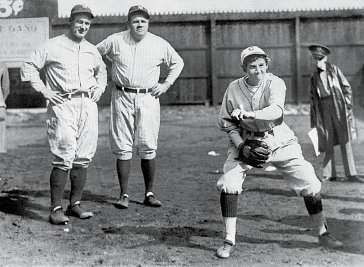 Jackie Mitchell pitches while Lou Gehrig (far left) and Babe Ruth (middle left) look on. Photo courtesy of the Library of Congress.